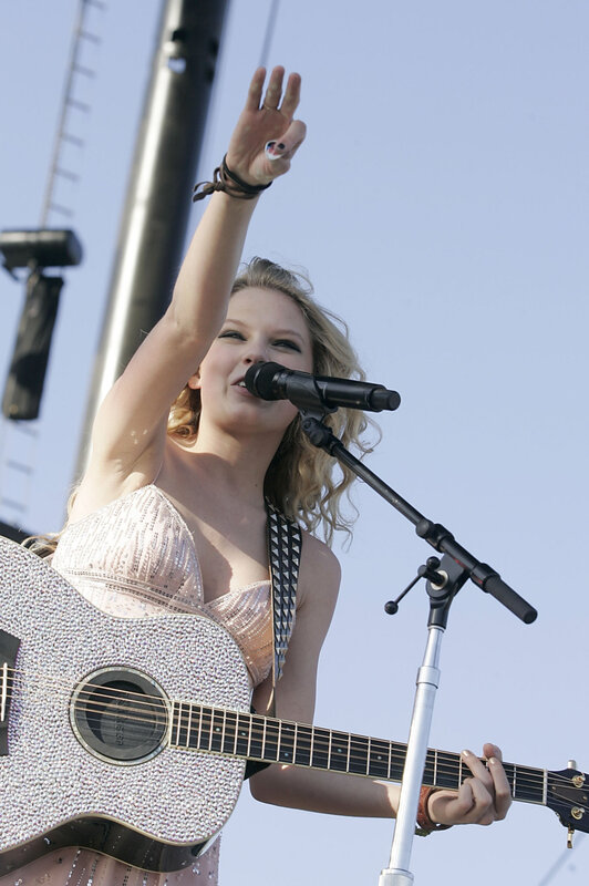 woman singing with guitar on stage