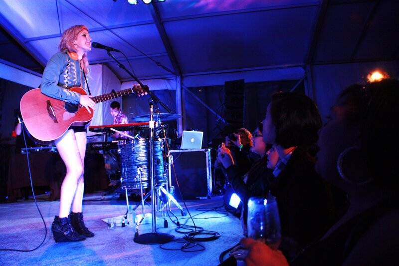 Woman singing with guitar on stage