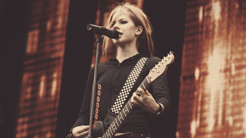 woman singing with guitar on stage