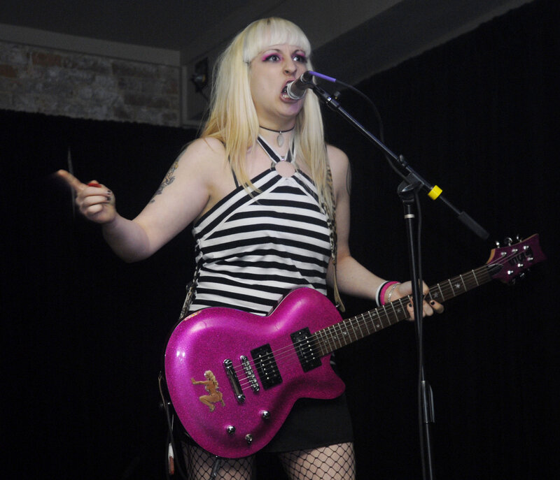 Woman singing with pink guitar