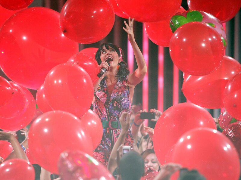 Woman singing with red balloons