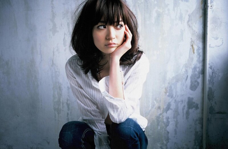 woman sitting against a wall