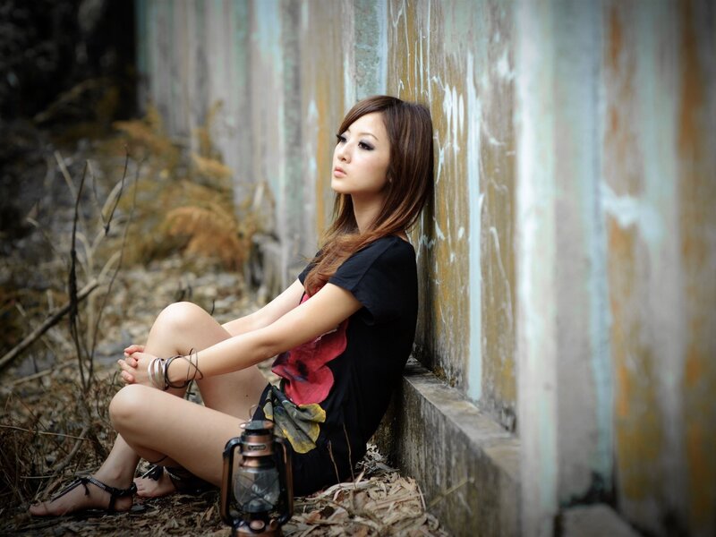 Woman Sitting Against Wall — Black, Contemplative, Photograph