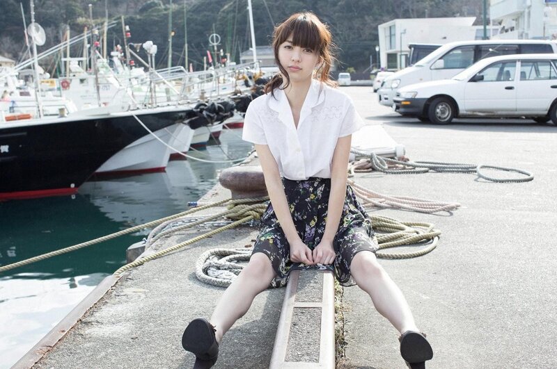 Woman sitting at a harbor