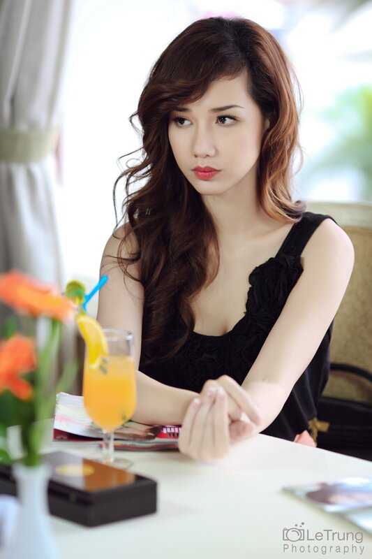 woman sitting at a table with drink