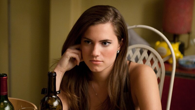woman sitting at table with wine bottles