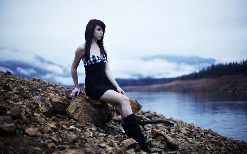 woman sitting by a lake