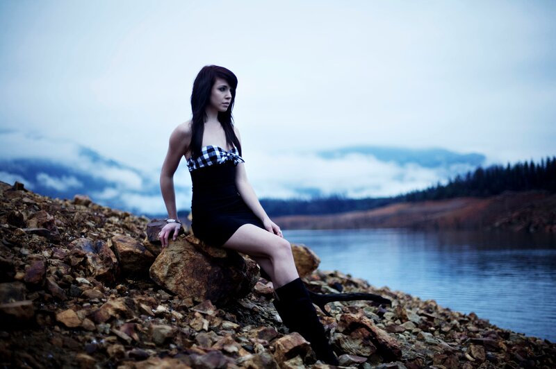 woman sitting by a lake