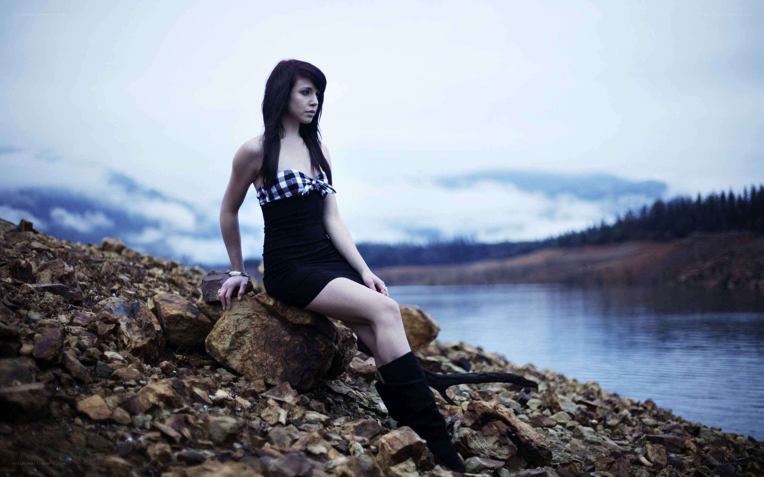 woman sitting by a lake