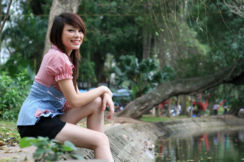 woman sitting by a pond