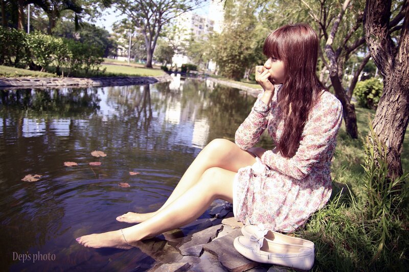 woman sitting by a pond