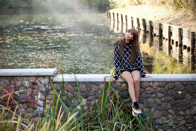 Woman sitting by a pond
