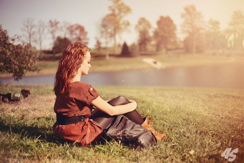 woman sitting by a pond