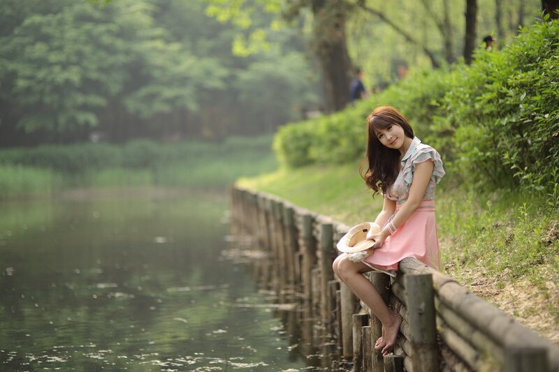 Woman sitting by a pond