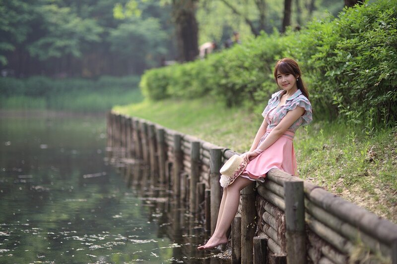 Woman sitting by a pond