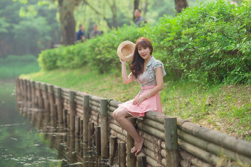 Woman sitting by a pond