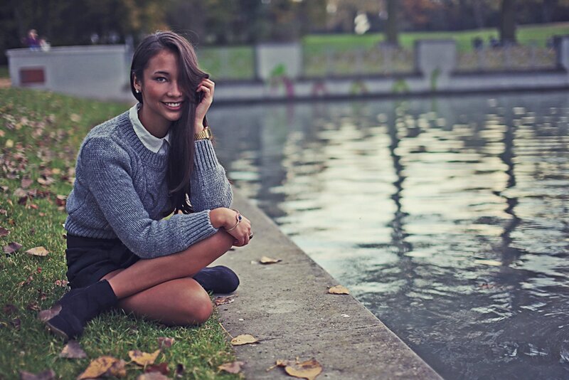 woman sitting by a pond