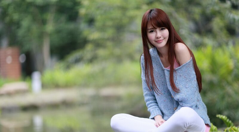 woman sitting by a pond