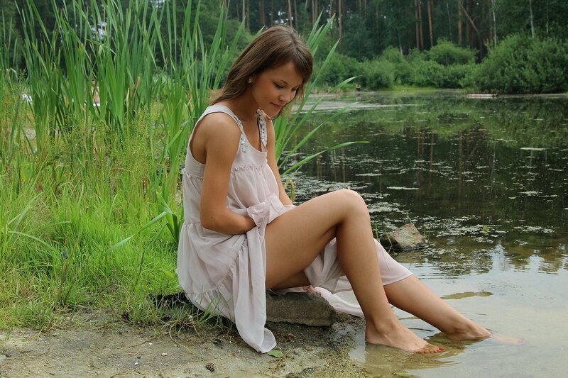 Woman sitting by a pond