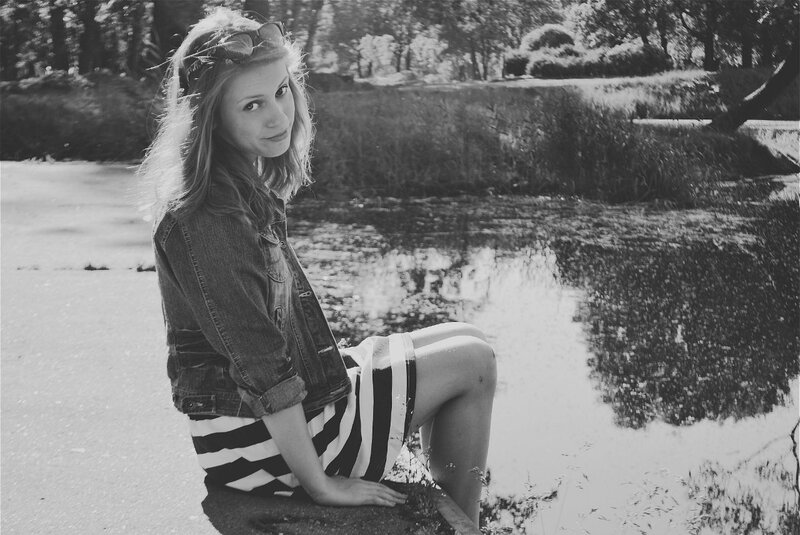 woman sitting by a pond
