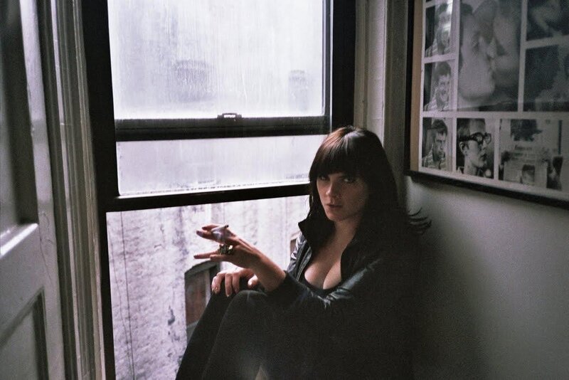woman sitting by a rainy window