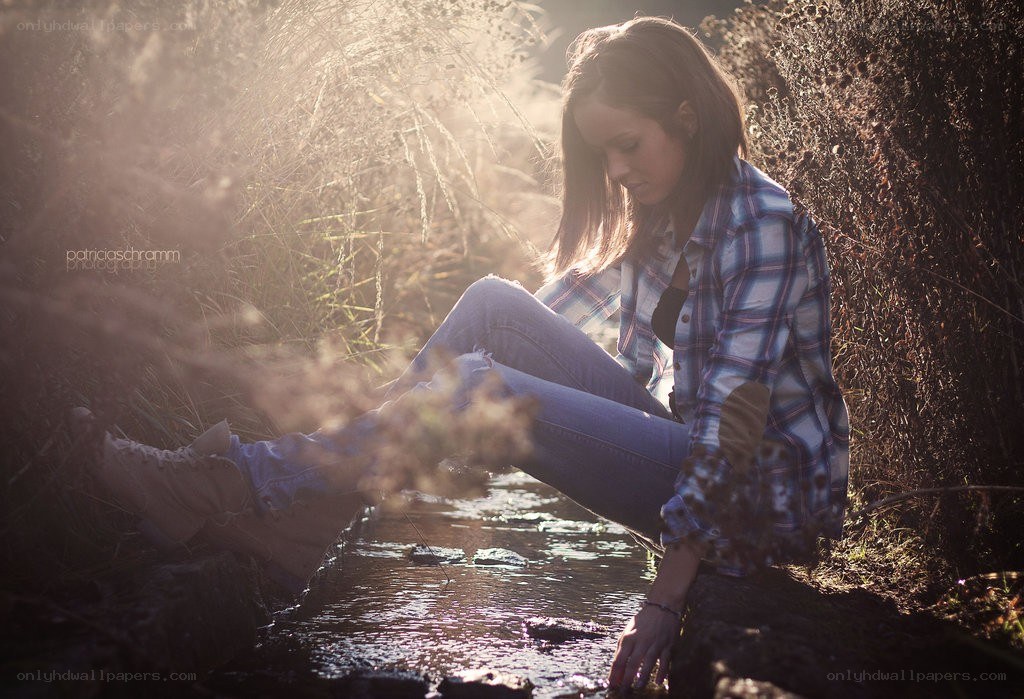 woman sitting by a stream