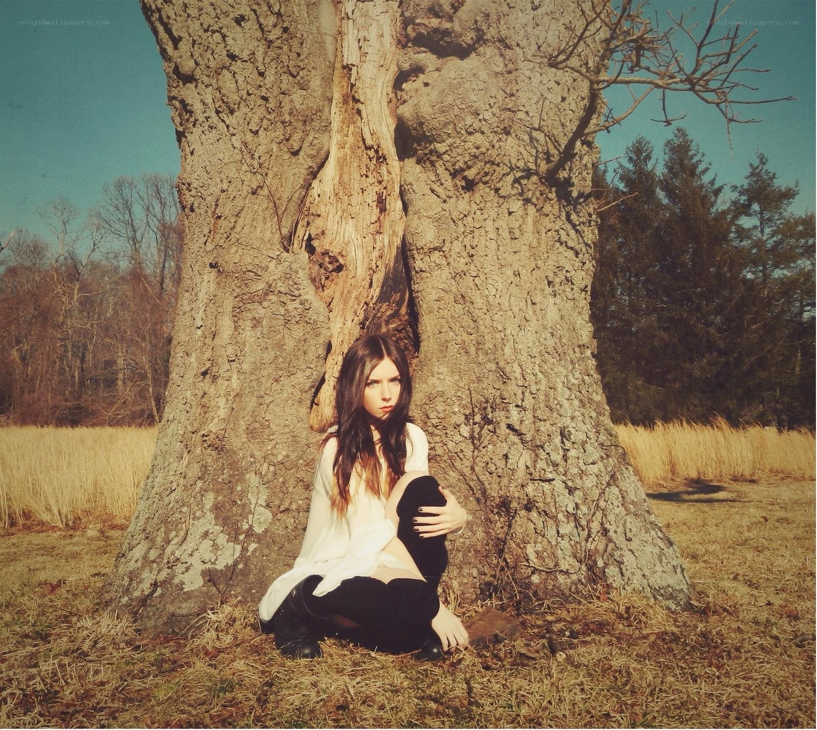 woman sitting by a tree