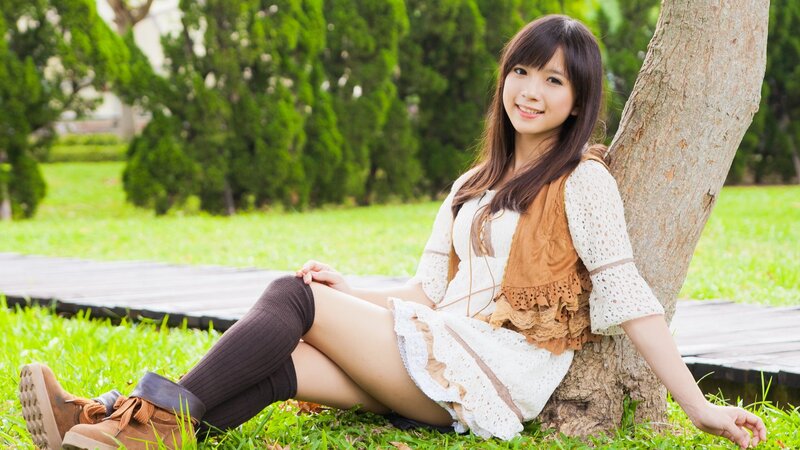 Woman sitting by a tree