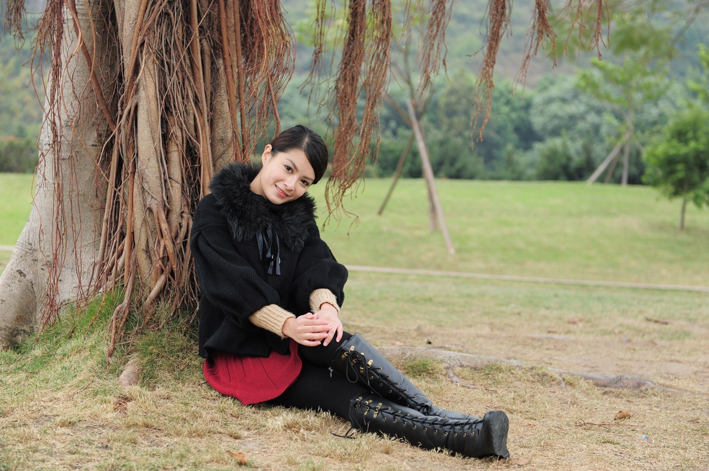 Woman sitting by a tree