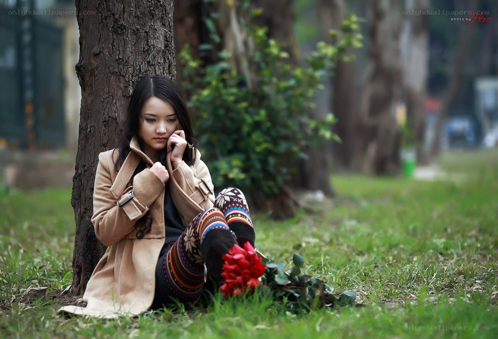Woman sitting by a tree