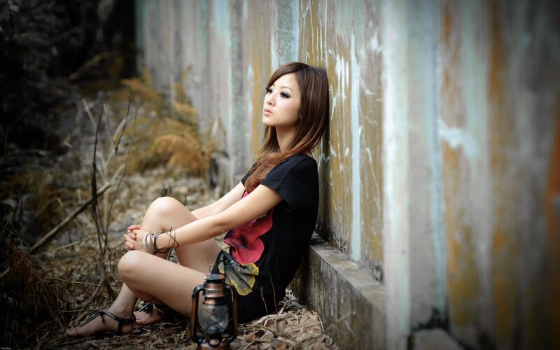 woman sitting by a wall