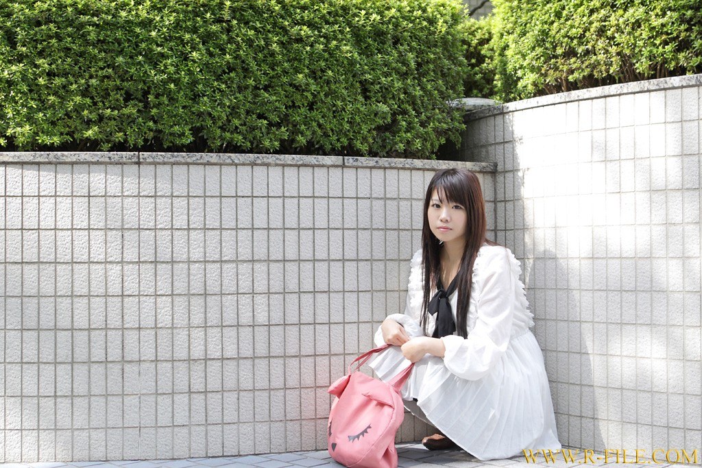 woman sitting by a wall