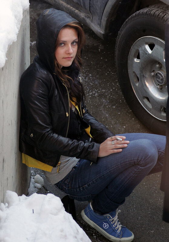 woman sitting by car in winter