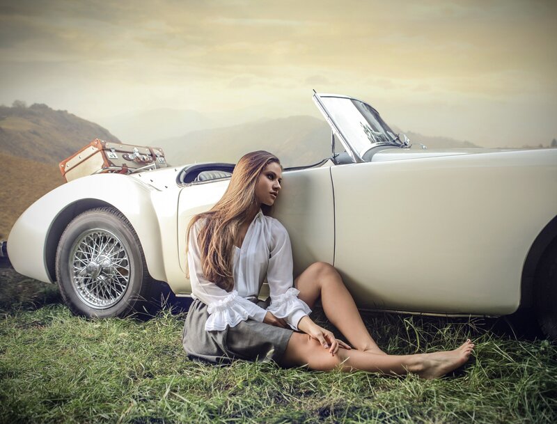 Woman Sitting by Car — White, Serene, Sunset, Photograph