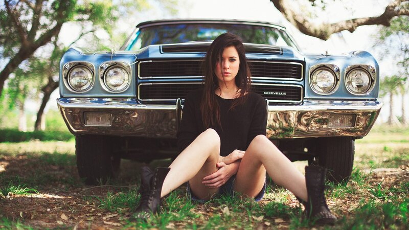 woman sitting by classic car