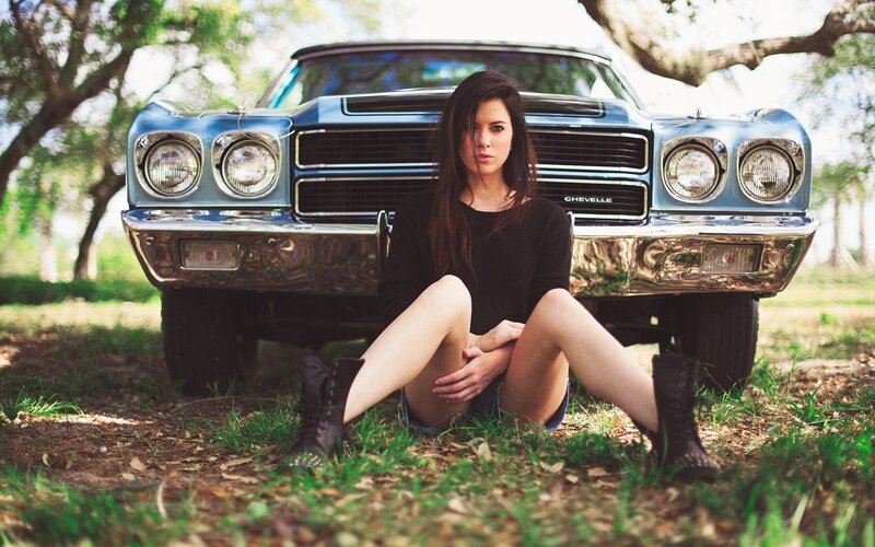 woman sitting by classic car