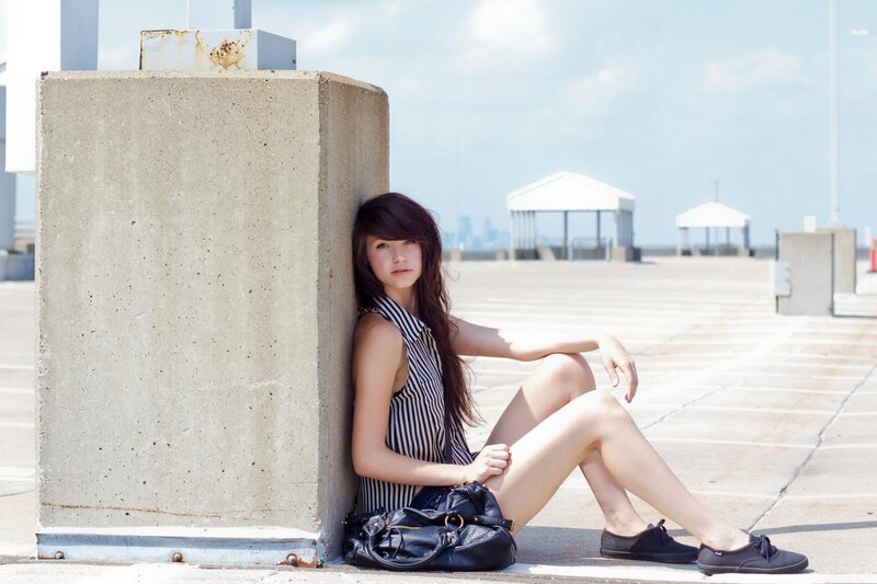 woman sitting by concrete pillar