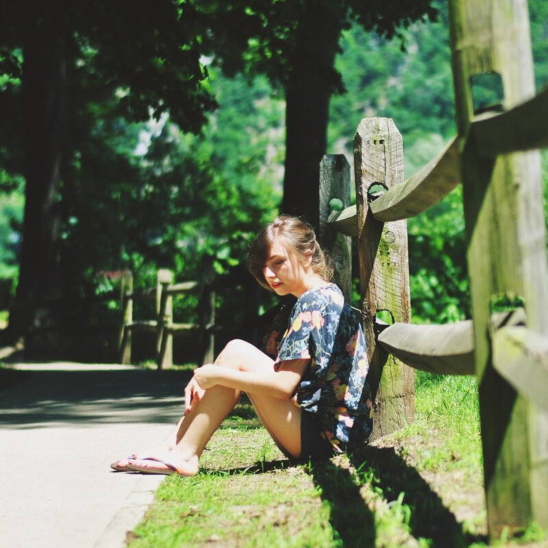 woman sitting by fence