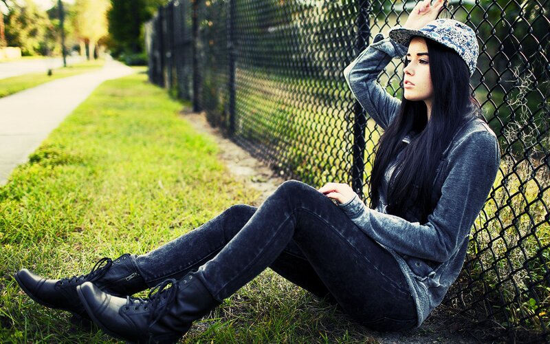 woman sitting by fence