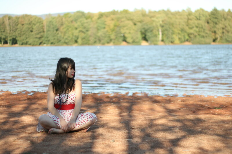 Woman Sitting by Lake — Brown