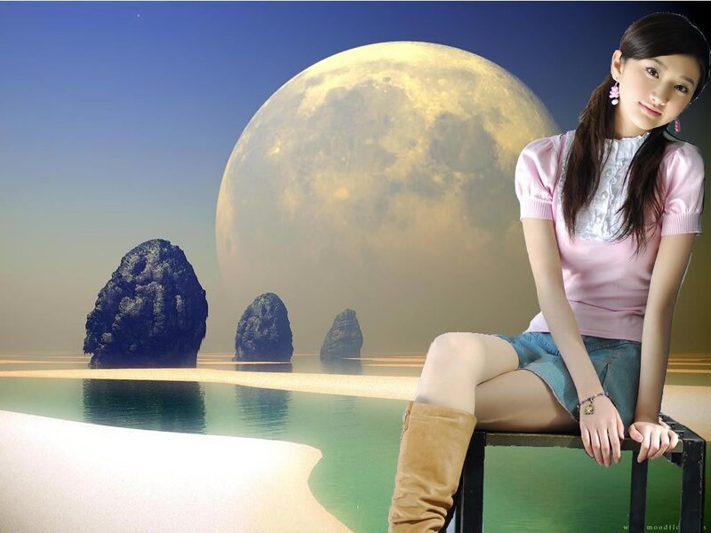 woman sitting by moonlit sea