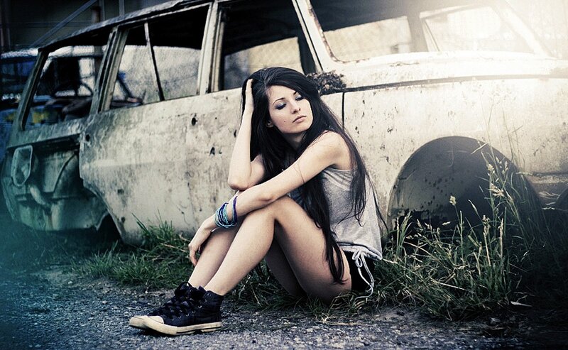 woman sitting by old car