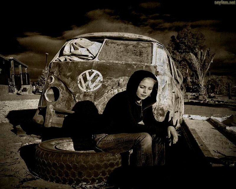 woman sitting by old van
