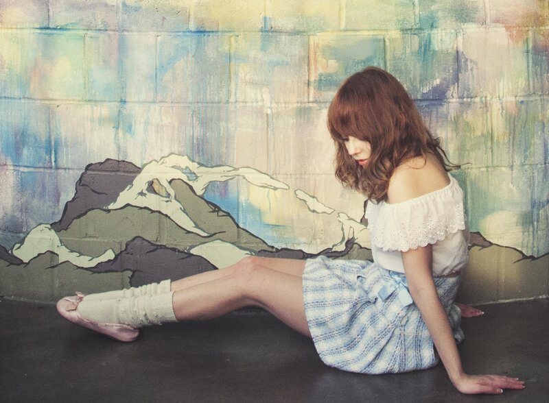 woman sitting by painted wall