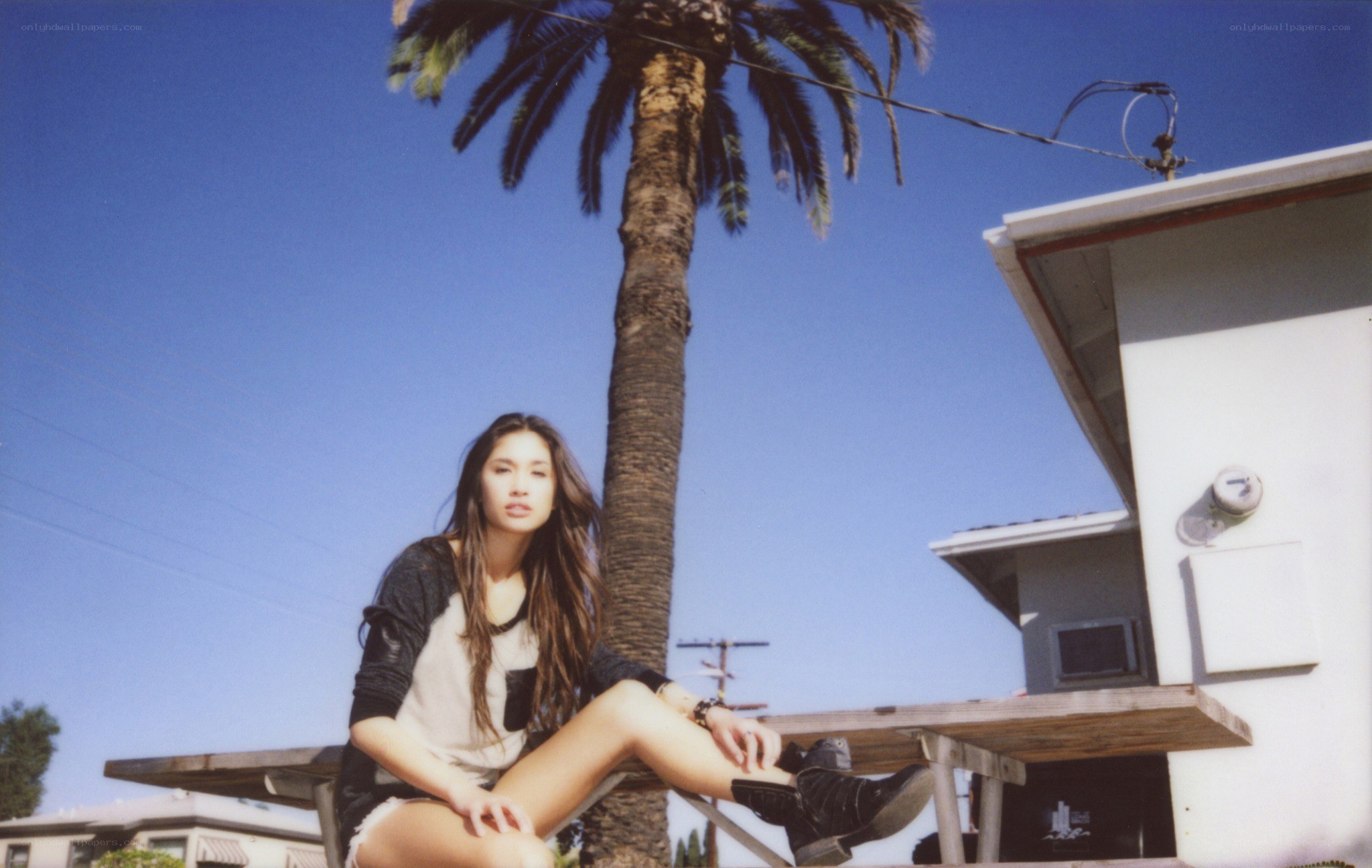 woman sitting by palm tree