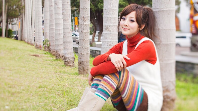 woman sitting by palm trees