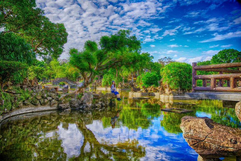 Woman Sitting by Pond — Green, Serene, Afternoon