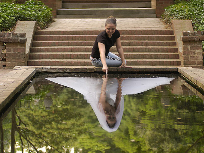 Woman Sitting by Pond