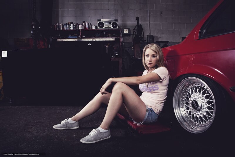 woman sitting by red car