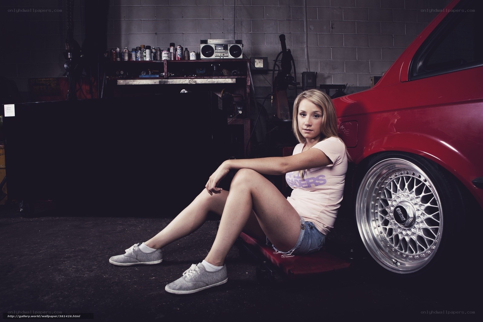 woman sitting by red car